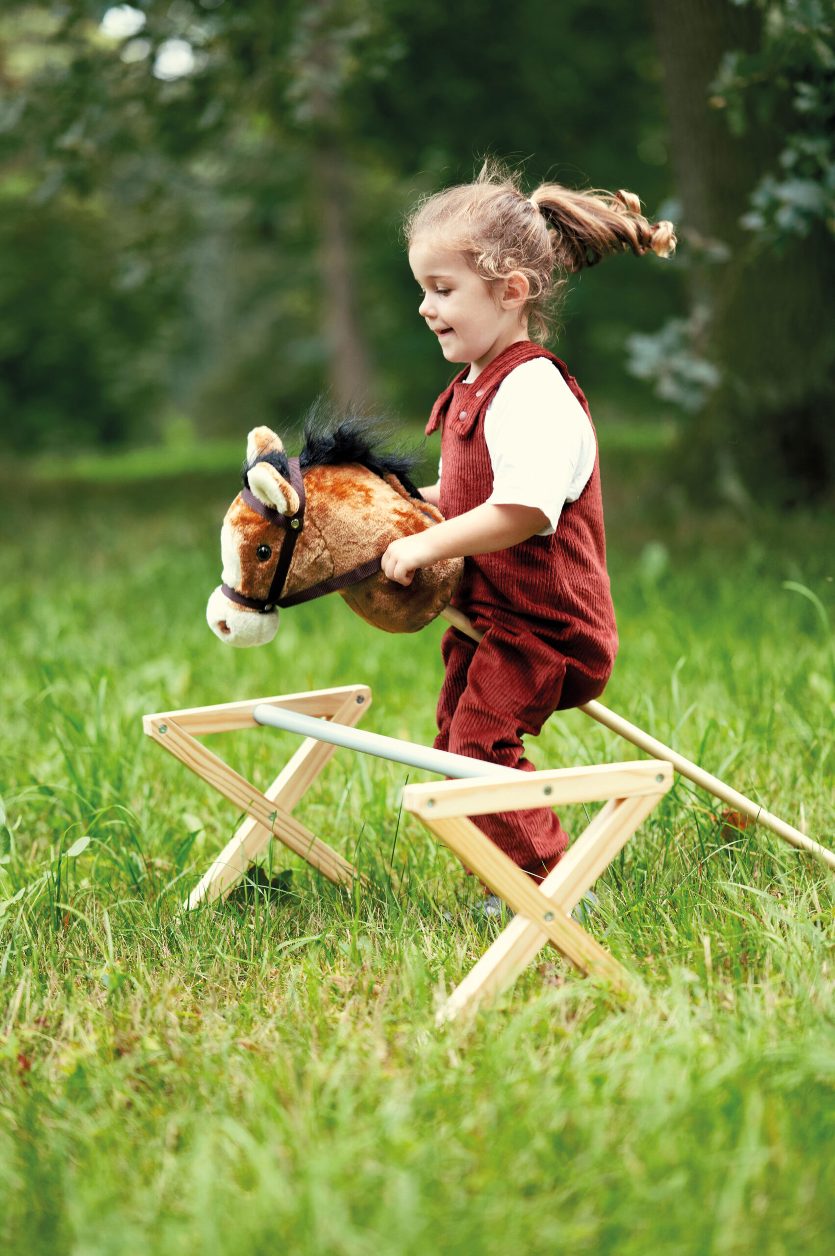 Meisje hobbyhorse buiten cavaletti spelen springen nico
