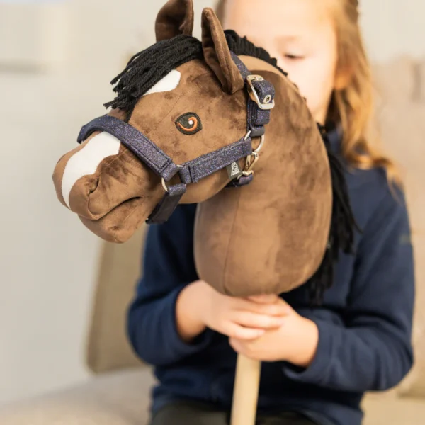 Meisje met bruin hobbyhorse met blauw navy glitter halster